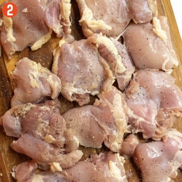 Seasoning chicken thighs with salt and pepper.