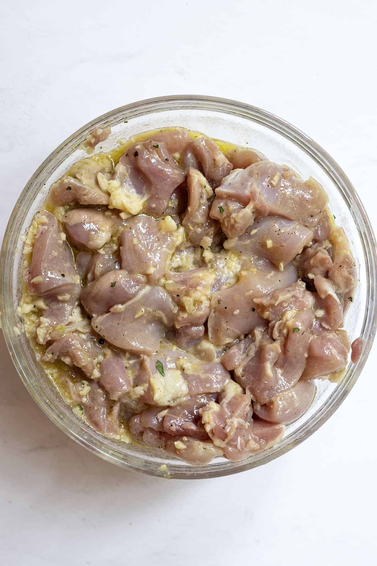 Grilled Chicken Skewers 6 Chicken thighs marinating in a bowl.