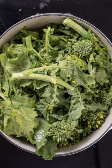 washed broccoli rabe added to oil