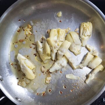 chopped artichokes added to the pan