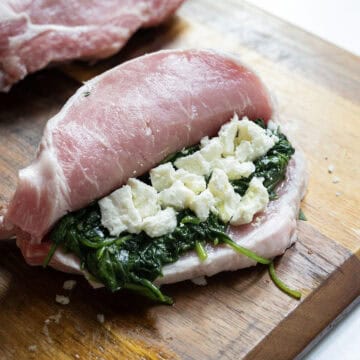 Raw butterflied pork chop stuffed with sauteed spinach and feta.