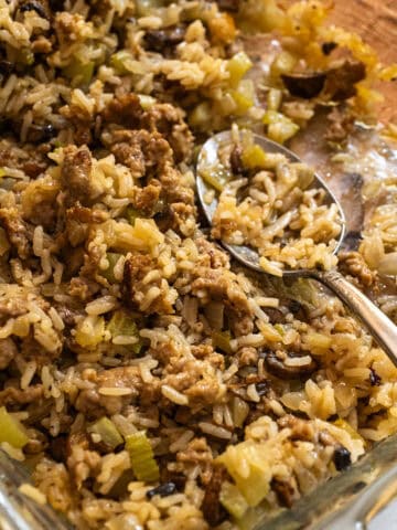 Rice dressing in an oven dish with a spoon.