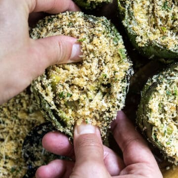 Stuffing artichoke with breadcrumb mixture.