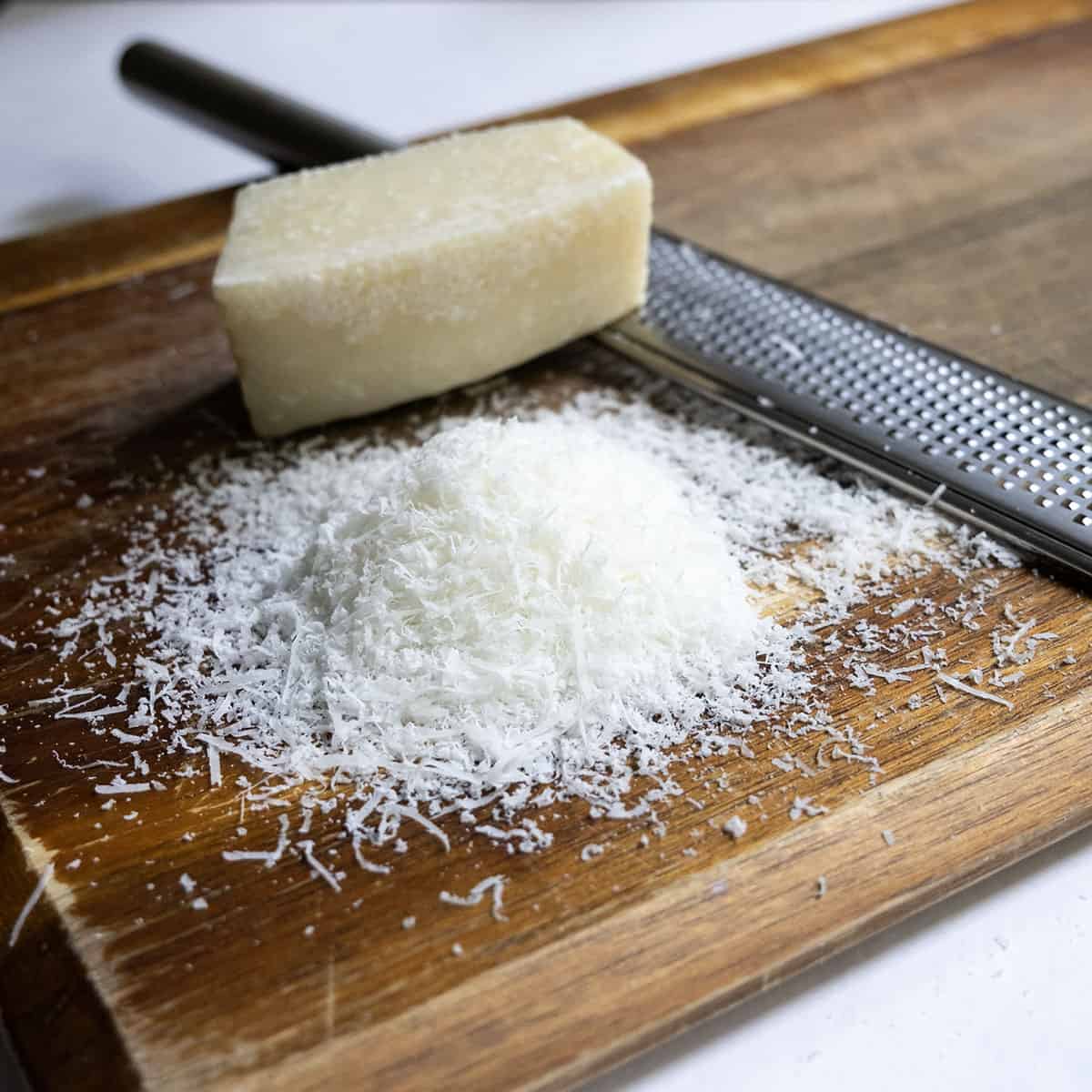 Finely grated pecorino romano on a cutting board.