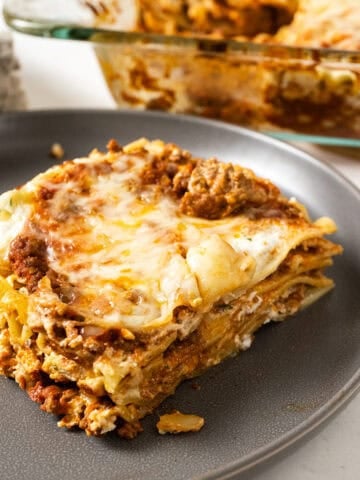 A square of lasagna on a plate.