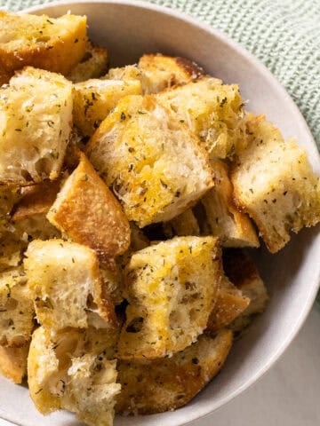 Parmesan seasoned croutons in a bowl.