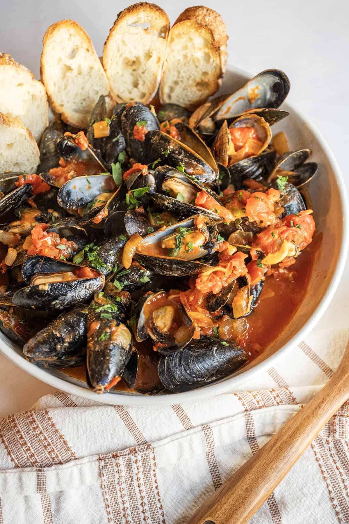 Mussels Fra Diavolo in a serving bowl with crostini.