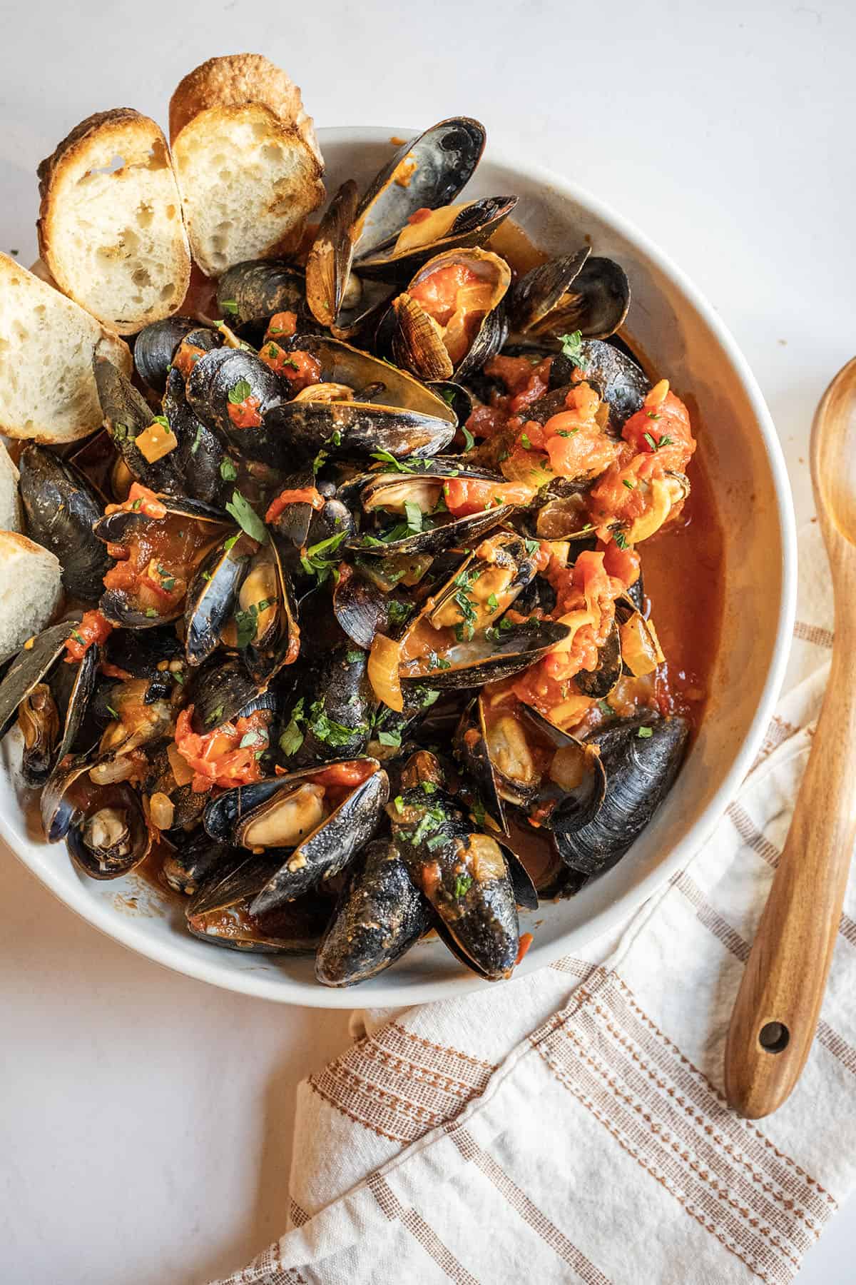 Mussels Fra Diavolo in a serving bowl with crostini.