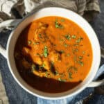 Butter chicken soup in a bowl topped with cilantro.