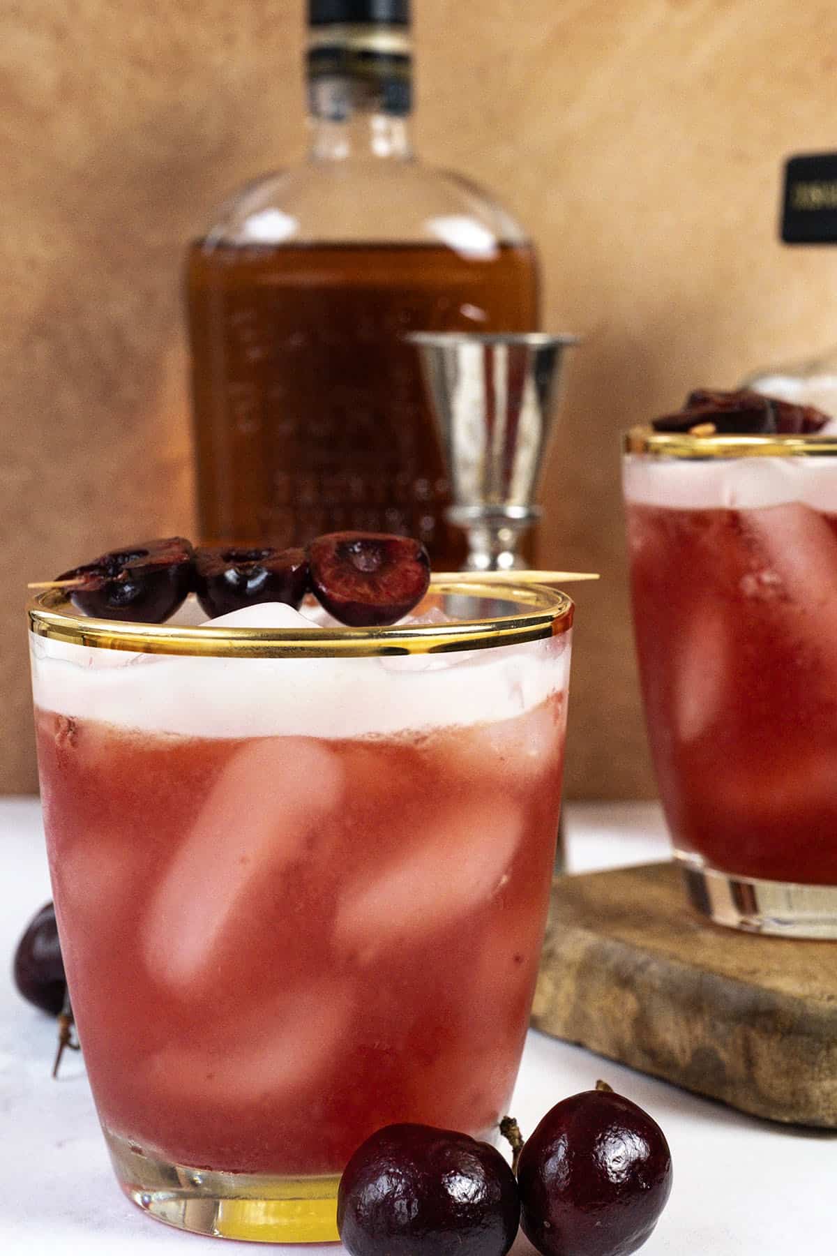 Cherry amaretto sour in a glass with a cherry garnish.