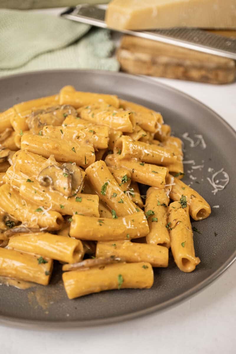 Creamy mushroom pasta on a plate garnished with parmesan.