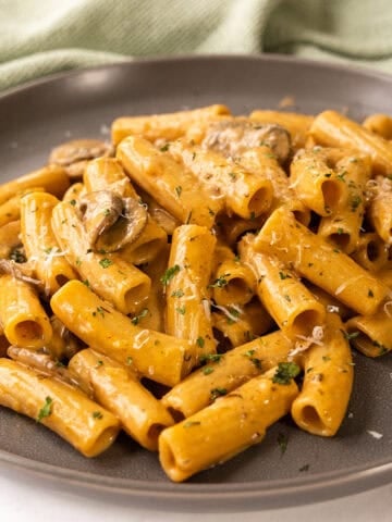 Creamy mushroom pasta on a plate garnished with parmesan.