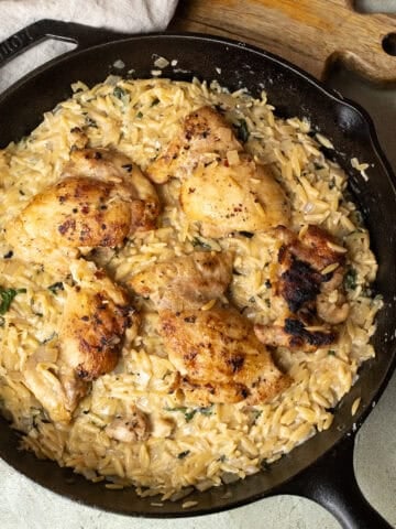 Charred chicken thighs over a bed of creamy orzo.