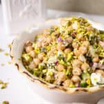 Chickpea and feta salad in a bowl topped with pistachios