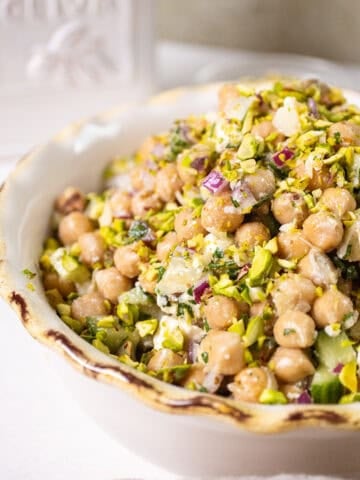 Chickpea and feta salad in a bowl topped with pistachios