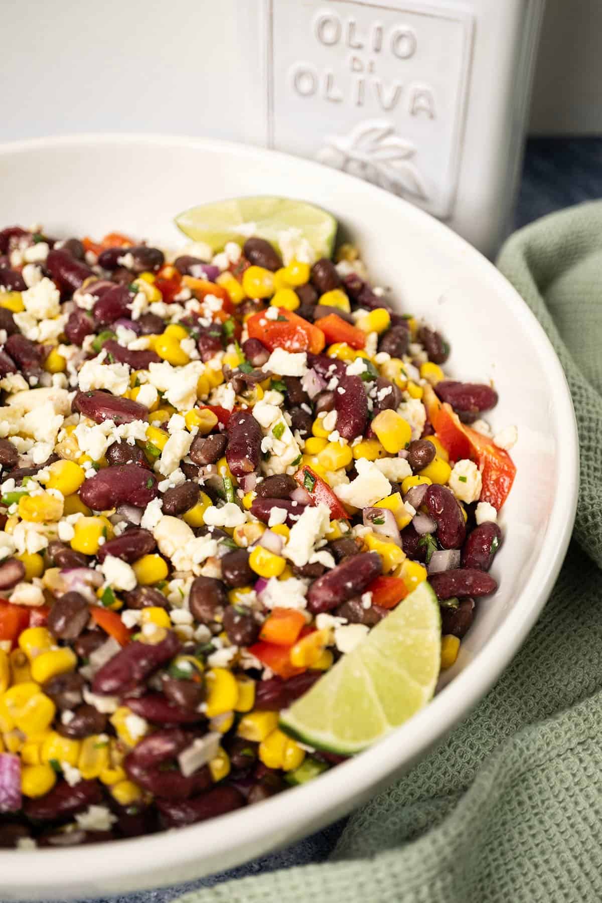 Cowboy caviar salad in a bowl, garnished with limes.