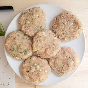 Ground chicken patties on a plate. 
