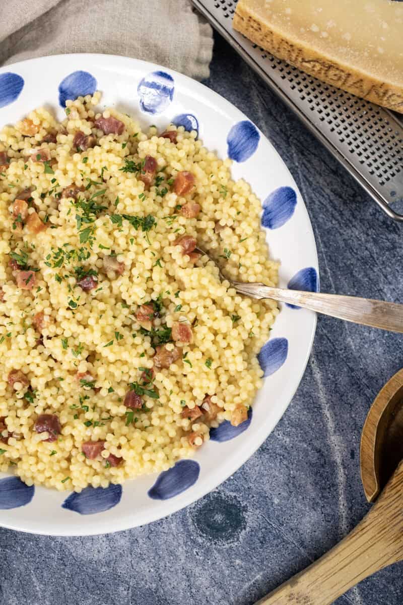 Pastina with pancetta and parsley in a bowl.