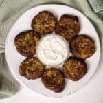 Air fryer zucchini fritters on a plate with aioli.