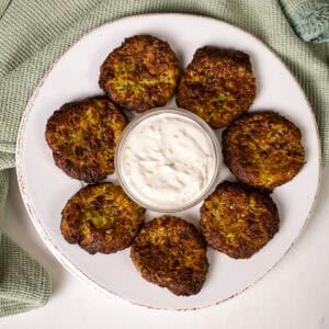 Air fryer zucchini fritters on a plate with aioli.