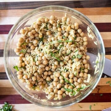 Combining dressing with beans and orzo.