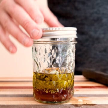 Mixing dressing in a mason jar.