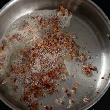 Pancetta frying in a sauce pan.
