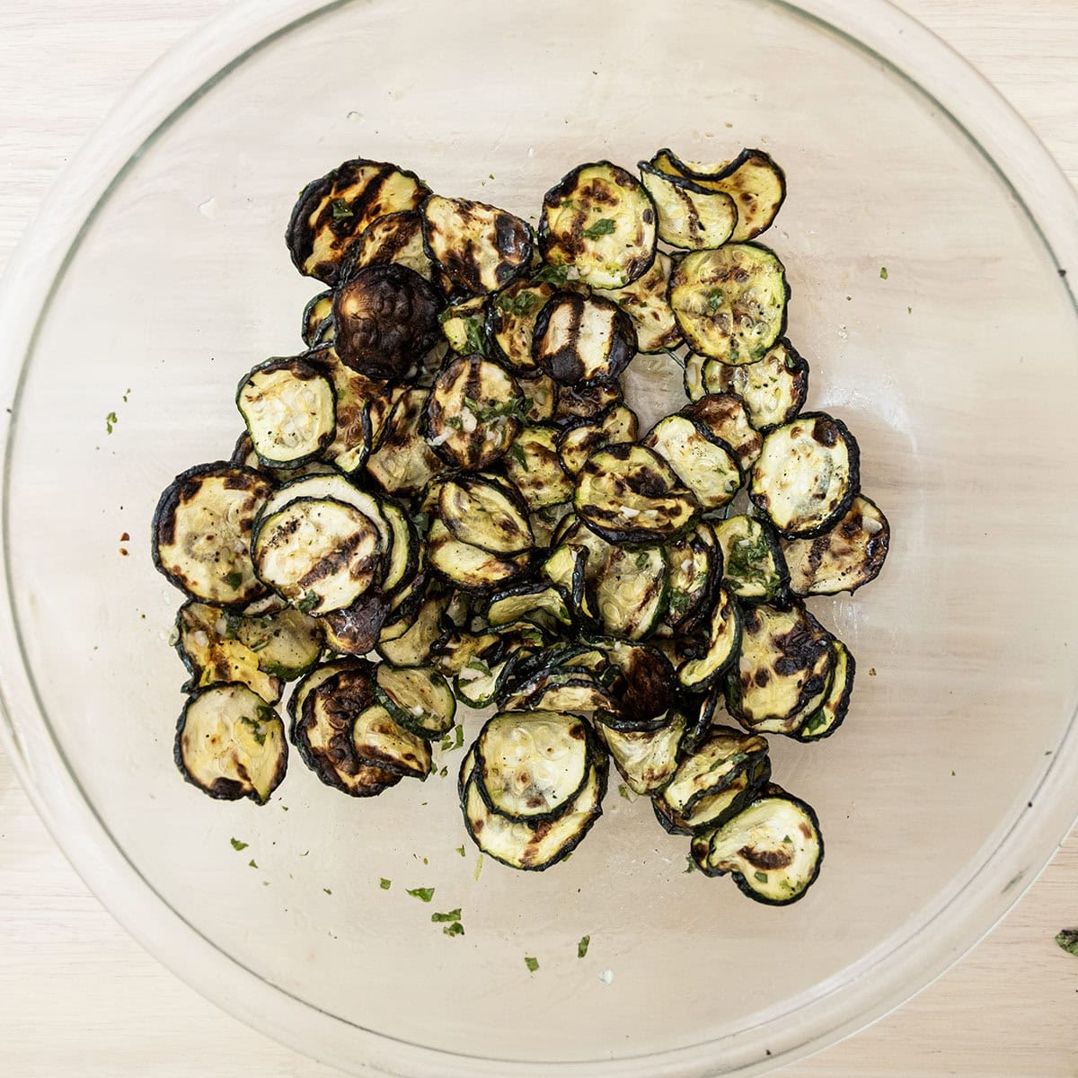 Grilled zucchini in a bowl tossed with mint dressing.