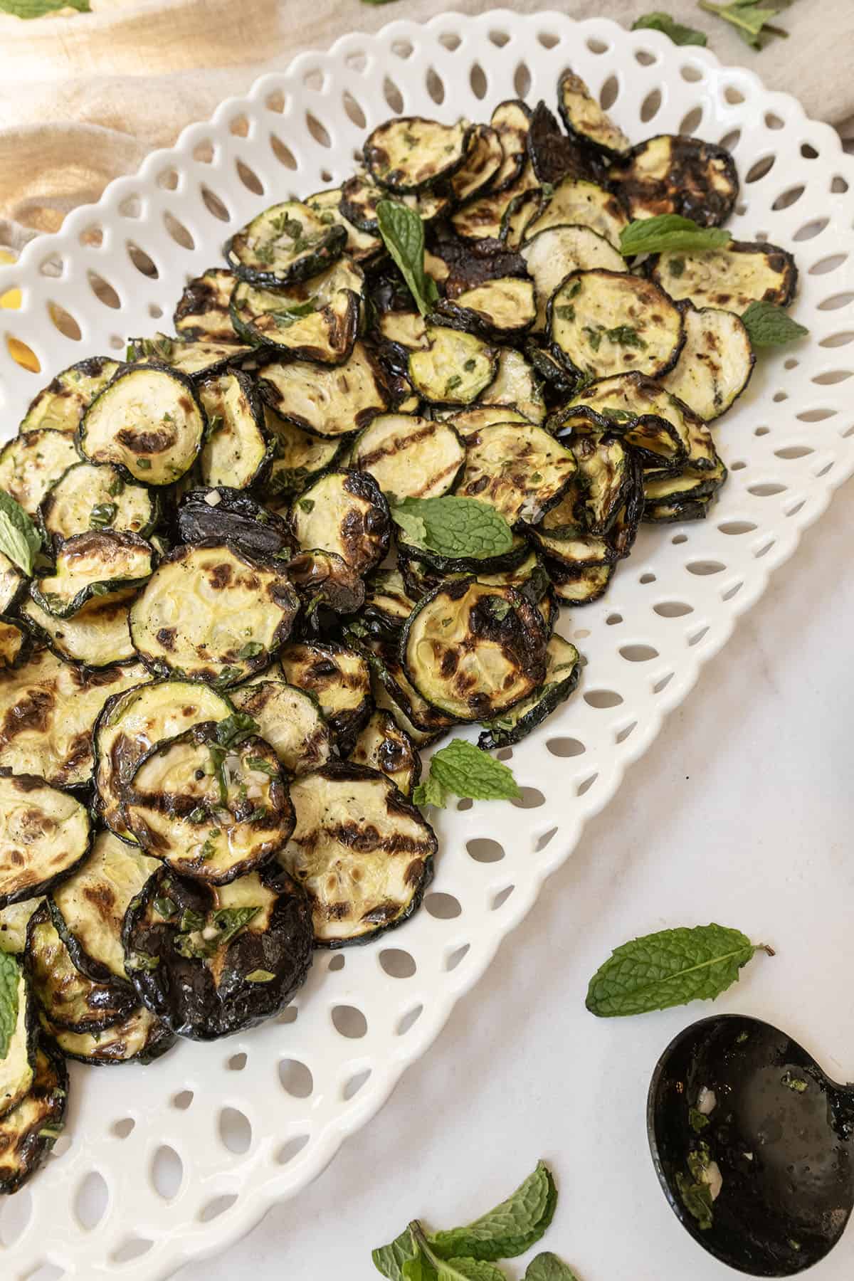 Zucchini alla scapece on a tray garnished with mint.