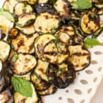 Zucchini alla scapece on a tray garnished with mint.