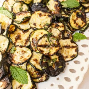 Zucchini alla scapece on a tray garnished with mint.