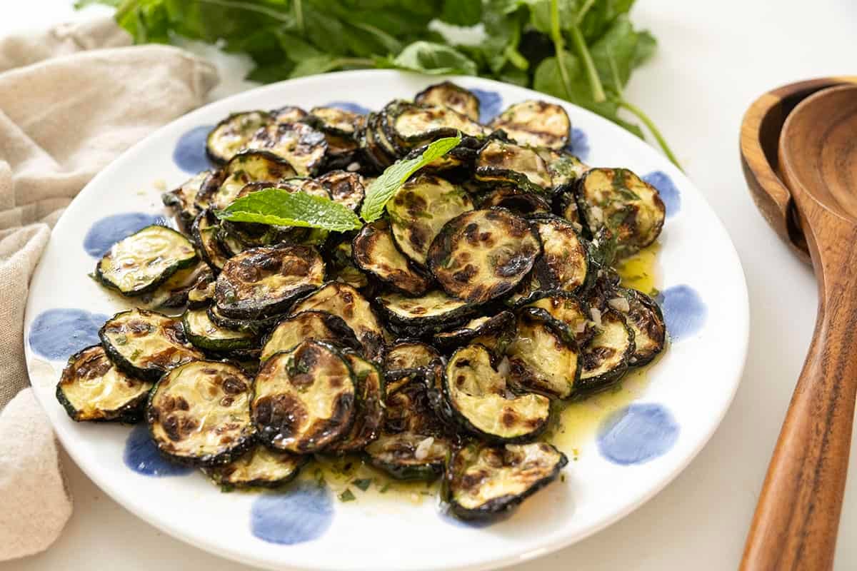 Zucchini alla scapece on a plate topped with mint. 