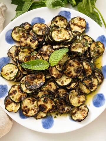 Zucchini alla scapece on a plate topped with mint.