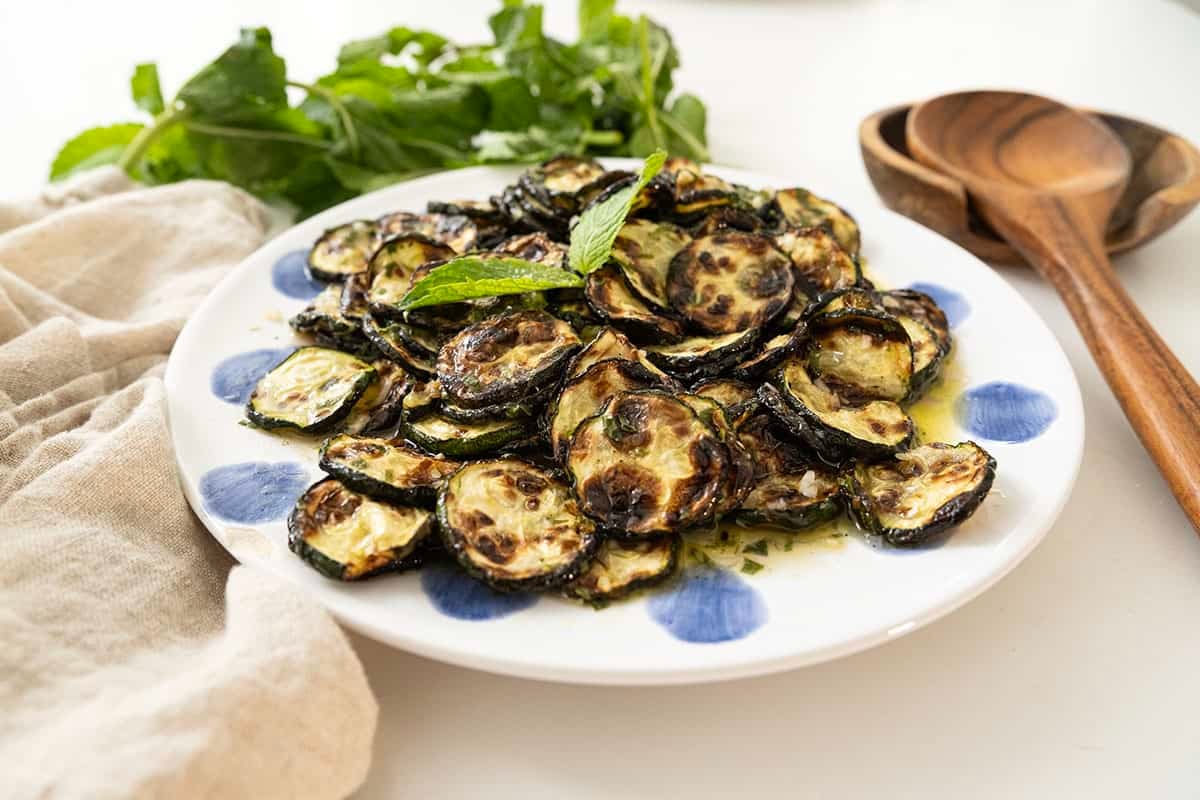 Zucchini alla scapece on a plate topped with mint.