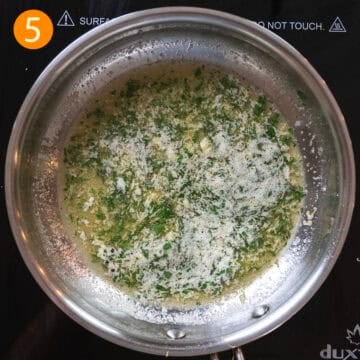 Garlic butter sauce in a pan with parsley.