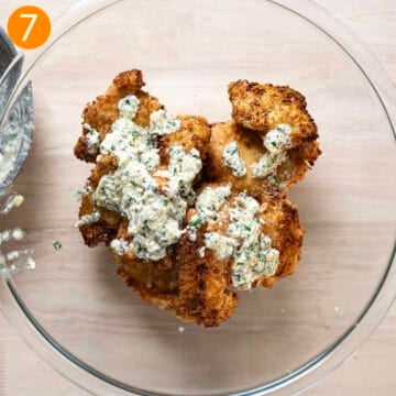 Air fried chicken thighs in a bowl with the sauce.