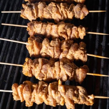 Raw chicken skewers on the grill.