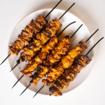 Bang Bang Chicken skewers on a plate.