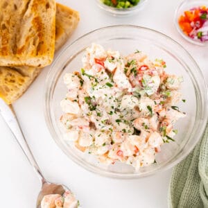 Cold shrimp salad in a bowl with a side of toasted bread.