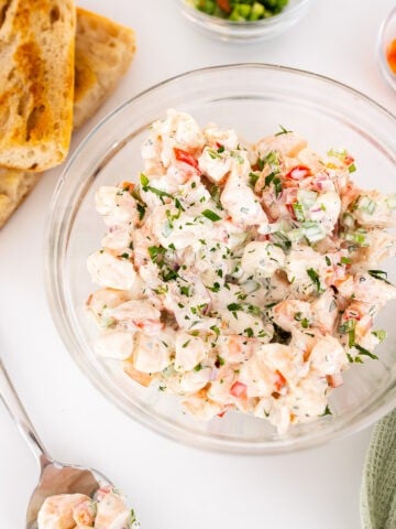 Cold shrimp salad in a bowl with a side of toasted bread.