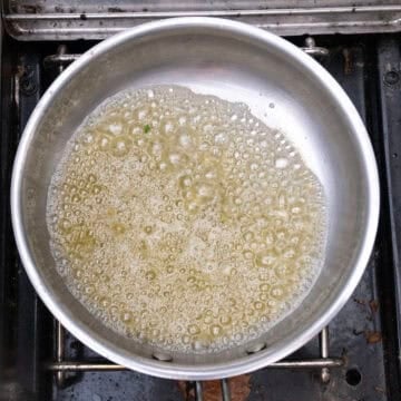 Simmering butter and garlic with lemon in a pot.