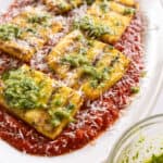 Grilled polenta on marinara topped with pesto and parmigiano.