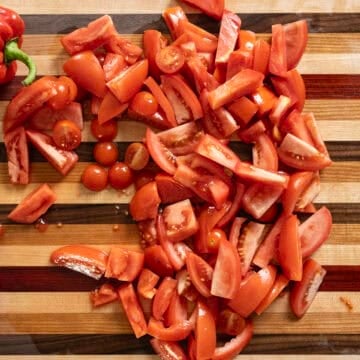 Chopped assorted tomatoes on a cutting board.