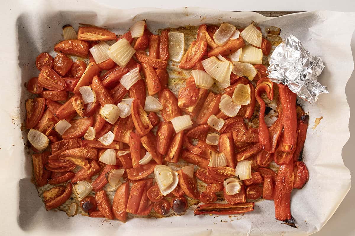 Roasting tomato, onion, and red pepper on a pan.