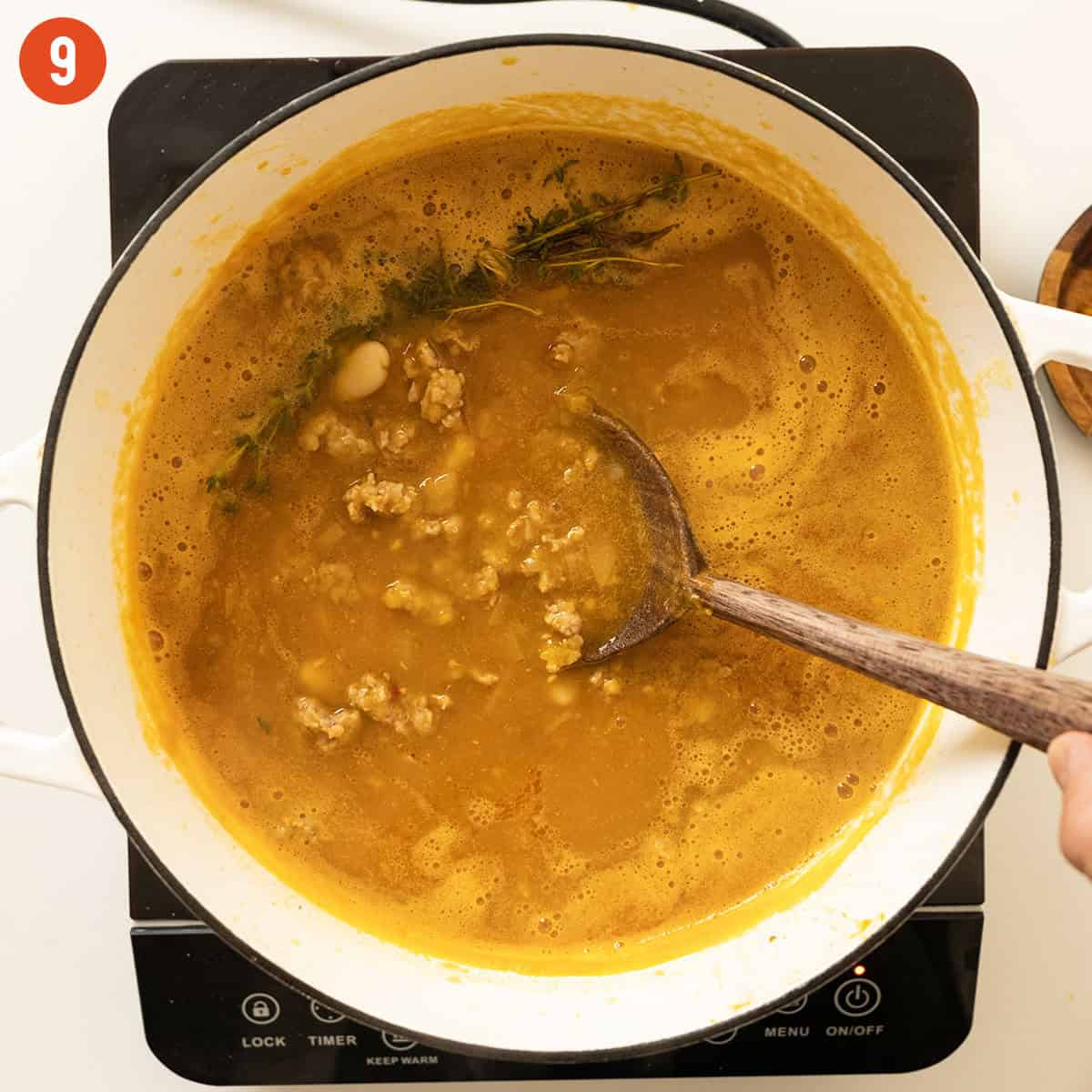 Simmering soup with sausage and beans.