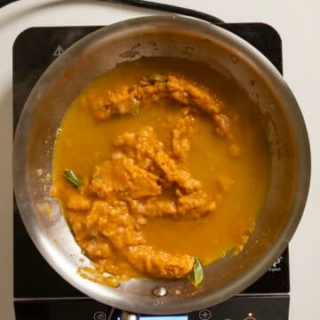 Pasta water added to pumpkin puree in the pan.