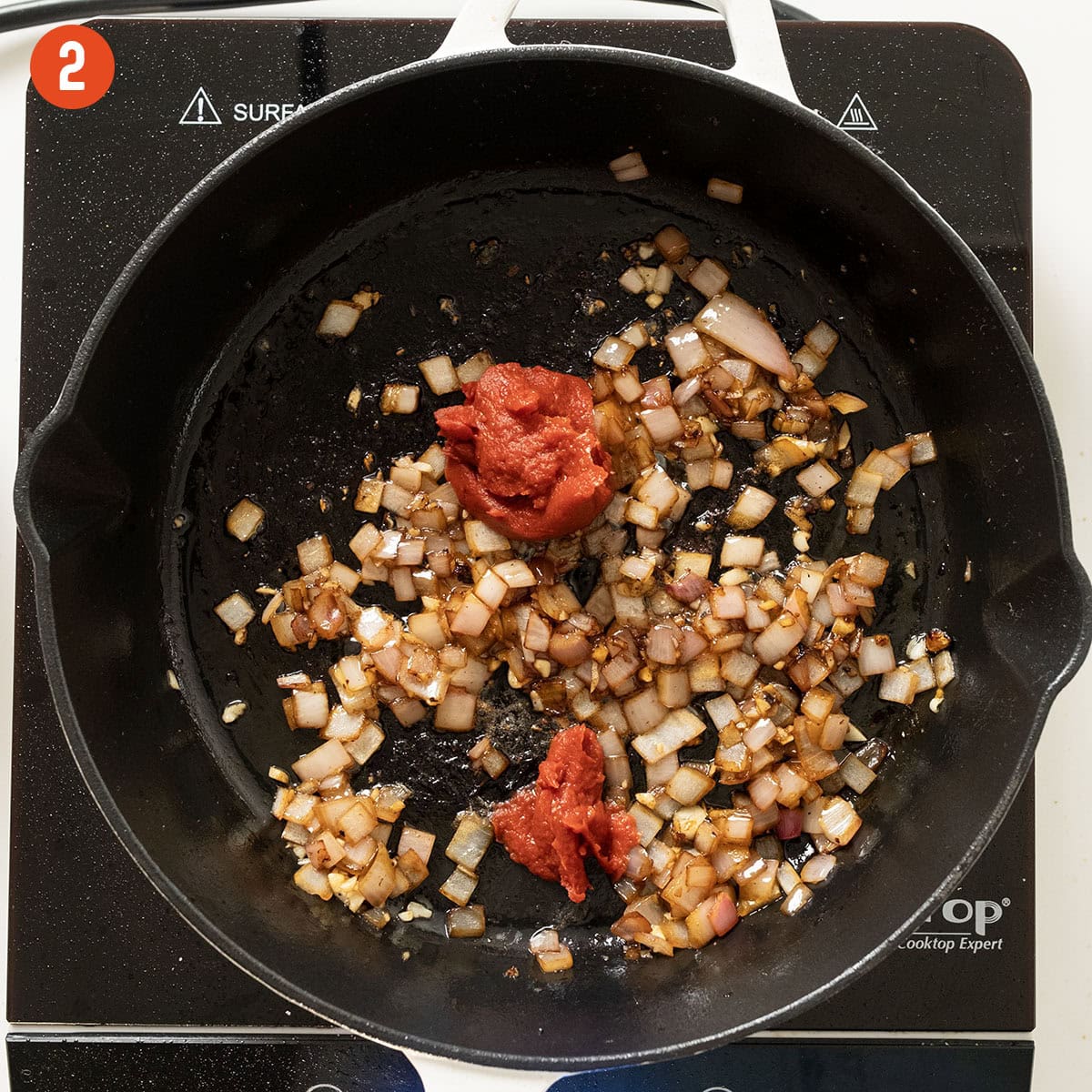 Caramelizing tomato paste in the saucepan with shallots.