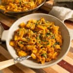 Pasta and Potatoes on a plate topped with parsley and parmesan.