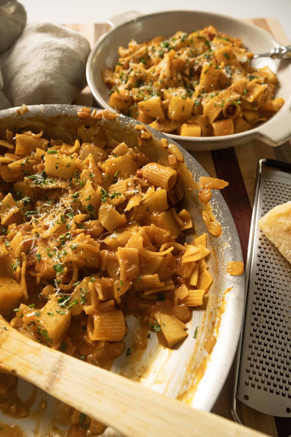 Pasta and Potatoes on a plate topped with parsley and parmesan.