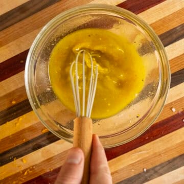 Whisking orange vinaigrette dressing.